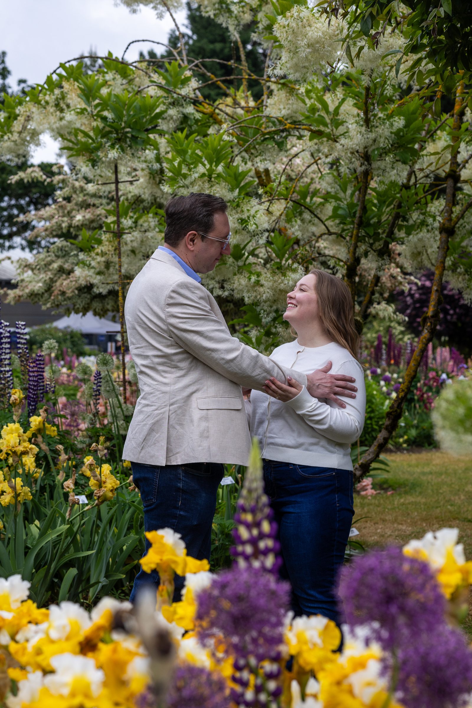 Rachel and Daniel laughing face to face among the blooms