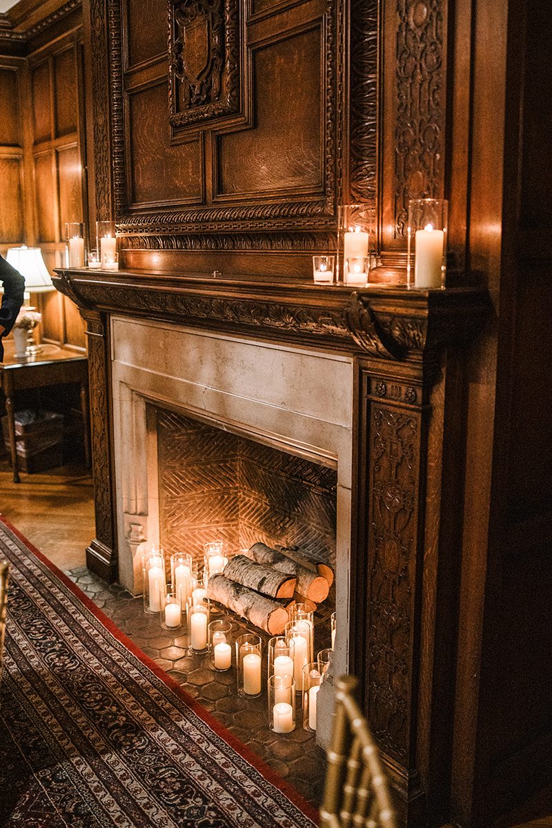 Ornate fireplace with candles in the wood-paneled lounge